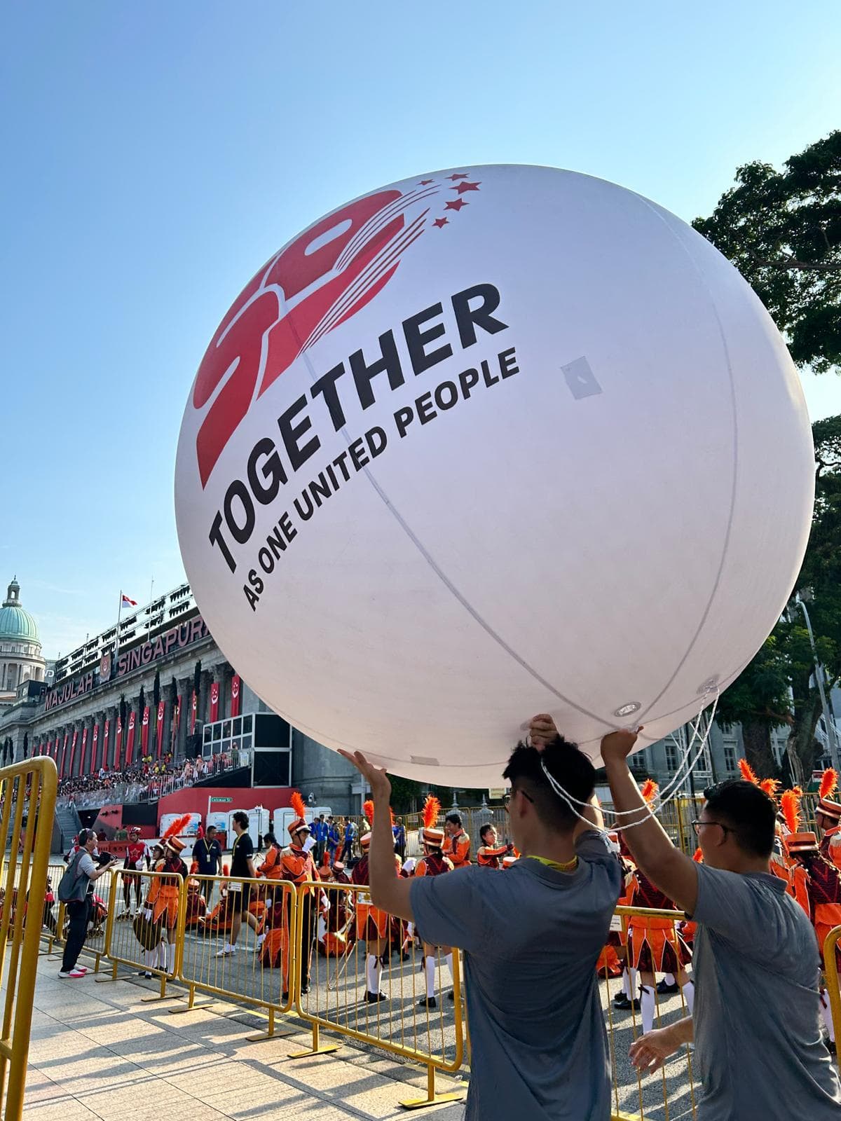 Giant SG59 sphere printed with Together as One United People, carried by crew at the Singapore National Day Parade
