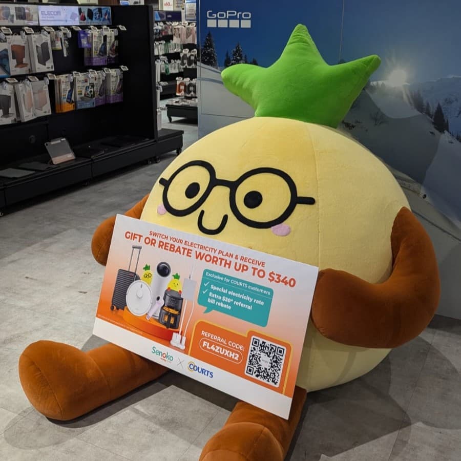 BB Ong Lai, a giant pineapple plushie display for Senoko Energy holding a campaign sign in a retail store