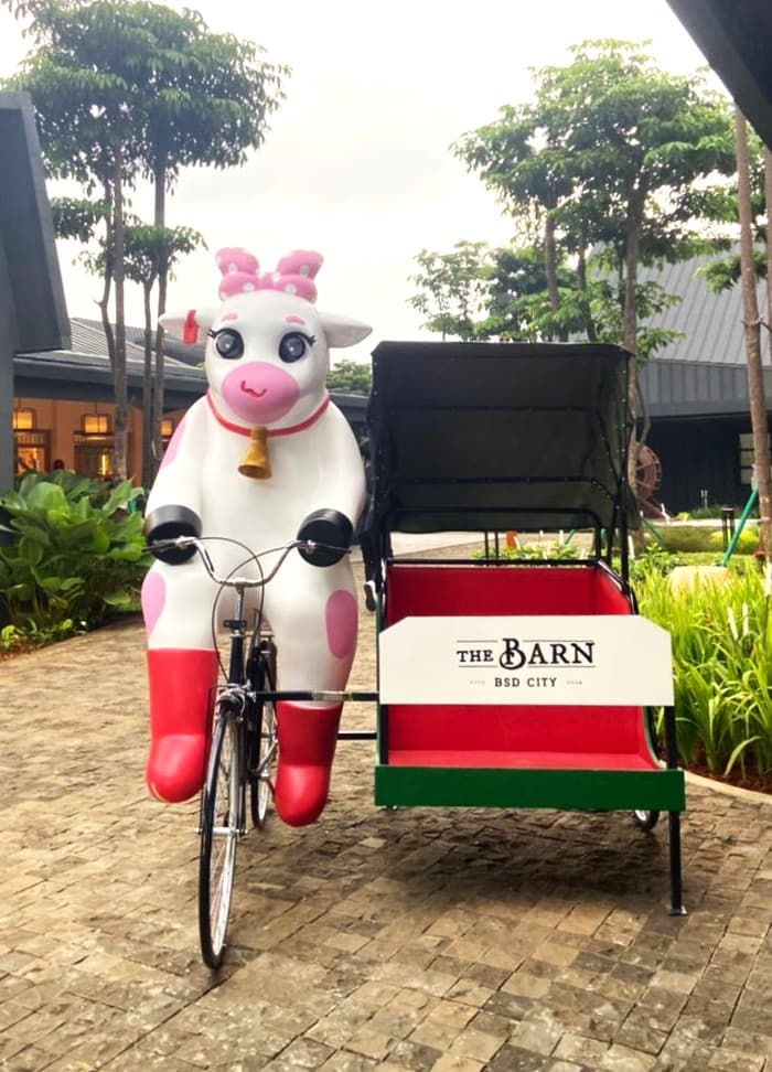 Pink and white cow statue riding a becak outside The Barn, BSD City, Indonesia